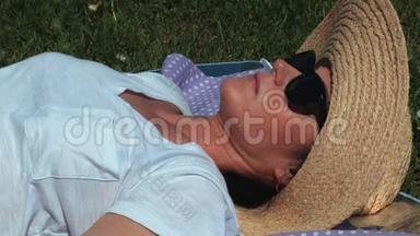 戴帽子的女人躺在草地上