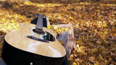 吉他躺在森林的黄叶上。黄叶落在吉他上。秋林