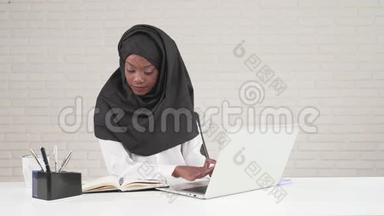 非洲女人在笔记本电脑上打字。