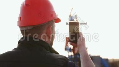 石油钻井<strong>平台</strong>上的工程师用<strong>智能</strong>手机拍照。 石油行业采用手机通讯..