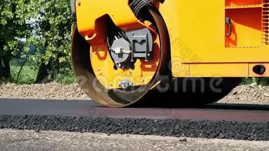 特写，道路建设工程与压路机压实机和沥青修整机。 压路机铺设新鲜沥青
