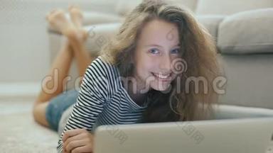 沙发上的少女正在从笔记本电脑上看书，微笑着看着相机