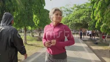 索洛莫万向<strong>节</strong>跟踪迷人的中年女士在城市公园<strong>跑步</strong>快乐。 40多岁的美女正在慢跑