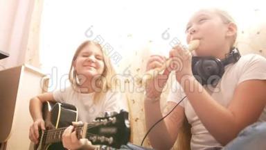 两名女青少年在家中<strong>坐在地板上</strong>演奏乐器、吉他和长笛
