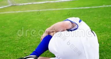受伤的足球运动员躺在草地上