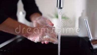 侧视和关闭男子洗手与肥皂以上水槽。 清洁手指和手掌。 自来水从水龙头里涌出来