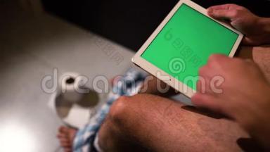 男人坐在马桶或锅上，手里拿着绿色屏幕的平板电脑的视频。 刷了好几下.. 滚动