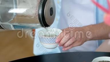 在茶壶里倒开水冲泡芳香可口的茶