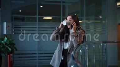 一个黑头发的漂亮女孩用智能手机聊天，喝咖啡。
