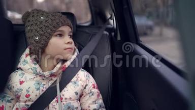 戴帽子的小女孩望着车窗外。