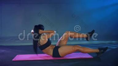 女运动员在健身房训练腹肌。