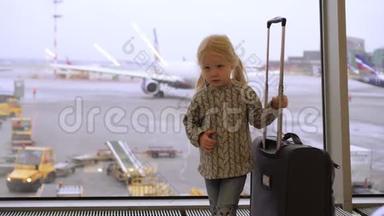 带着手提箱的女孩子在机场。 孩子在机场候机室。
