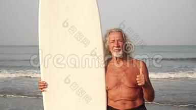 在海滩上有冲浪板的老头竖起大拇指