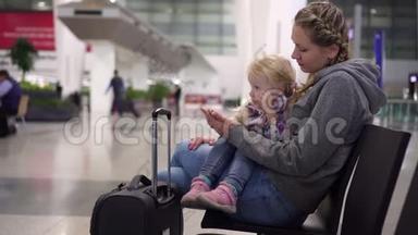 妈妈和女儿在机场休息室。 在机场有孩子的女人