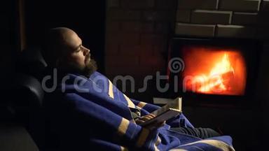 长胡子的人睡在壁炉附近的摇椅上。 湿度概念
