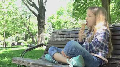儿童在公园吃冰淇淋，儿童在游乐场坐在长凳上放松
