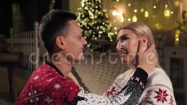 一个男人的特写镜头轻轻地<strong>抚摸</strong>着他女朋友的头靠近圣诞树