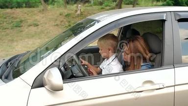 一个小男孩和他的母亲坐在汽车的<strong>车轮</strong>上，打开<strong>雨</strong>刷。