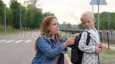 一位有爱心的母亲在放学前调整他背上的背包。