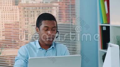 在<strong>耳机</strong>里和某人说话，在电脑上工作的黑人<strong>特写</strong>。