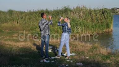 不负责任的年轻人在湖边的公园里扔了一个空玻璃瓶