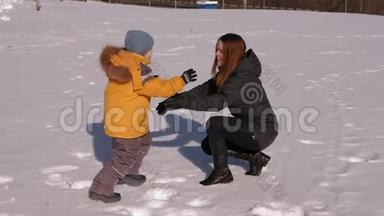 小男孩从雪地里<strong>跑到</strong>妈妈`怀里，他们落在雪地上。