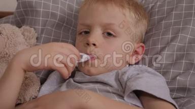 一个小男孩得了水痘，他用温度计测<strong>量体温</strong>。