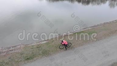 专业骑自行<strong>车</strong>的人站在大湖附近。 三项运动员准备自行<strong>车</strong>训练的<strong>俯视</strong>图。 戴头盔的女人