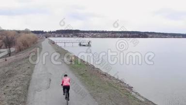在大坝附近<strong>骑</strong>公路自行车的女人。 三项运动员在外面<strong>骑</strong>自行车。 <strong>骑</strong>自行车的人在公园里<strong>骑</strong>自行车
