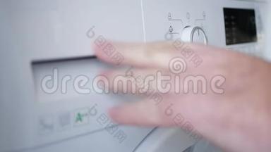 男人把脏衣服放进洗衣机，<strong>设定</strong>程序，打开电源