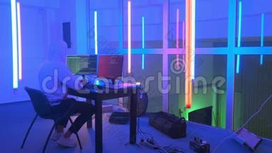 黑客工作场所：黑客在一个有彩色霓虹灯的房间里工作