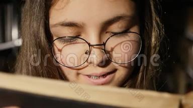 戴眼镜的女孩在<strong>图书馆看书</strong>，特写