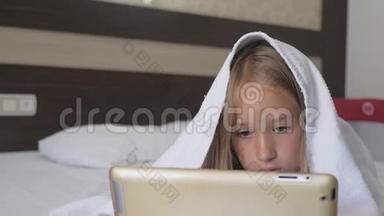 十几岁的<strong>女孩</strong>在床上玩<strong>社交网络</strong>上的平板电脑。 特写小<strong>女孩</strong>在数字平板上看视频..