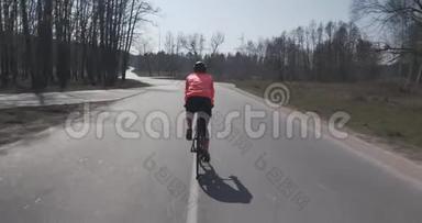 女人骑着自行车使劲蹬。 戴头盔的女三项运动员骑自行车。 女运动员在空路上骑自行车。 三项全能比赛