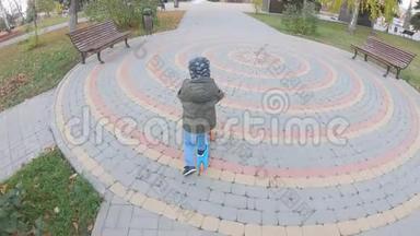 小男孩在城市公园里学骑滑板车。 主动休闲和儿童户外运动。