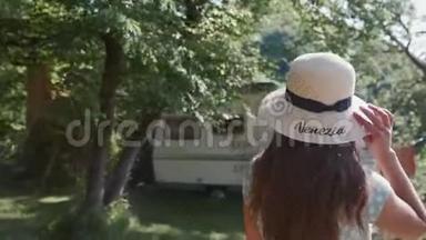 跟着一个戴着帽子、穿着浪漫服装的女人，去森林里的露营车