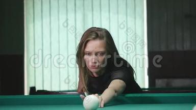 年轻漂亮的年轻女士在一家<strong>俱乐部</strong>里靠在桌子上时，瞄准了斯诺克的<strong>射击</strong>