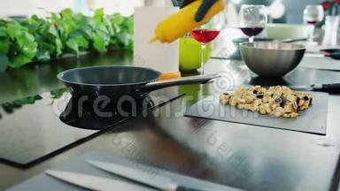 厨师`用现代设备在厨房用炒锅炒菜时，用手套把他的手合起来
