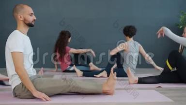 女孩和男人一<strong>起坐</strong>在灯光室里享受瑜伽练习