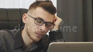 男面睡办公室，特写.. 戴眼镜的人在工作中睡觉。 商人在工作场所睡着的肖像。 累了