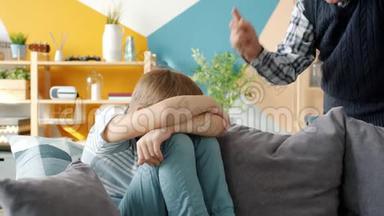 严厉的祖父惩罚<strong>小男孩</strong>对坐在沙发上<strong>哭泣</strong>的孩子摇着手指