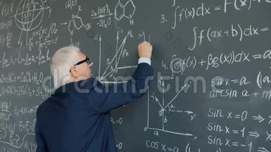 大学教授在课堂上用黑板书写公式动作缓慢