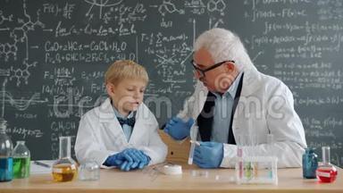 小学生和教授在课堂上讨论化学实验