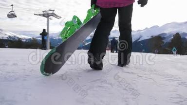 在滑雪场，女孩滑雪者手里拿着滑雪板。 雪山上的运动女人。 滑雪冬季阳光明媚
