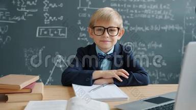 教室里戴着眼镜微笑着坐在桌前的小天才画像