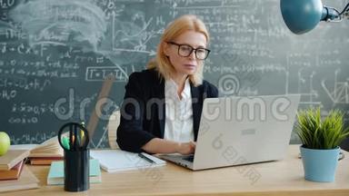 大学教授使用笔记本电脑，然后在课堂上做笔记