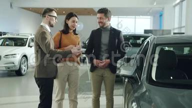 友好的专业汽车经销商与兴高采烈的客户讨论新车