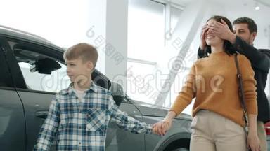年轻的家庭母亲、父亲和孩子<strong>买车</strong>给拥抱的女人带来惊喜