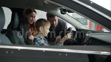 慢动作快乐的人<strong>爸爸妈妈</strong>和孩子选择汽车，男孩玩方向盘