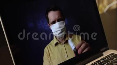 一位戴着医疗面具的视频博主正在笔记本电脑€™网络摄像头上录制广告视频。 他向他的订阅者介绍